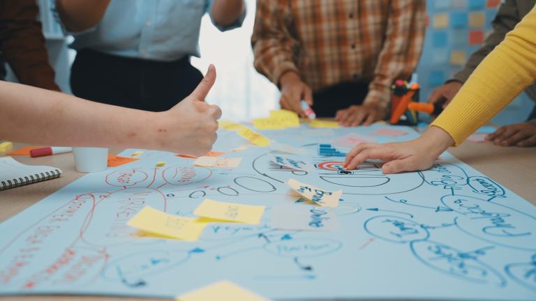 brainstorming stock image of people working on a colourful mind map together